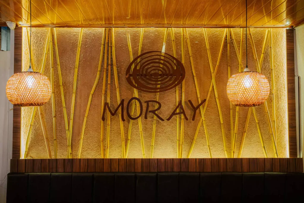Illuminated golden wall with the Moray emblem in the restaurant, Cusco