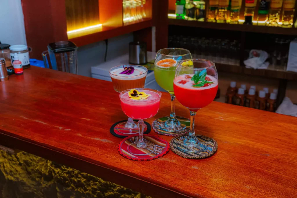 Colorful pisco cocktails on the bar at Moray, Cusco