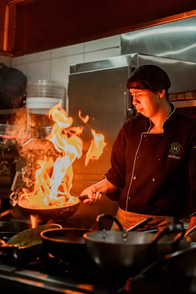 Chef flambéing a wok in the kitchen of Moray Peruvian Cuisine, Cusco