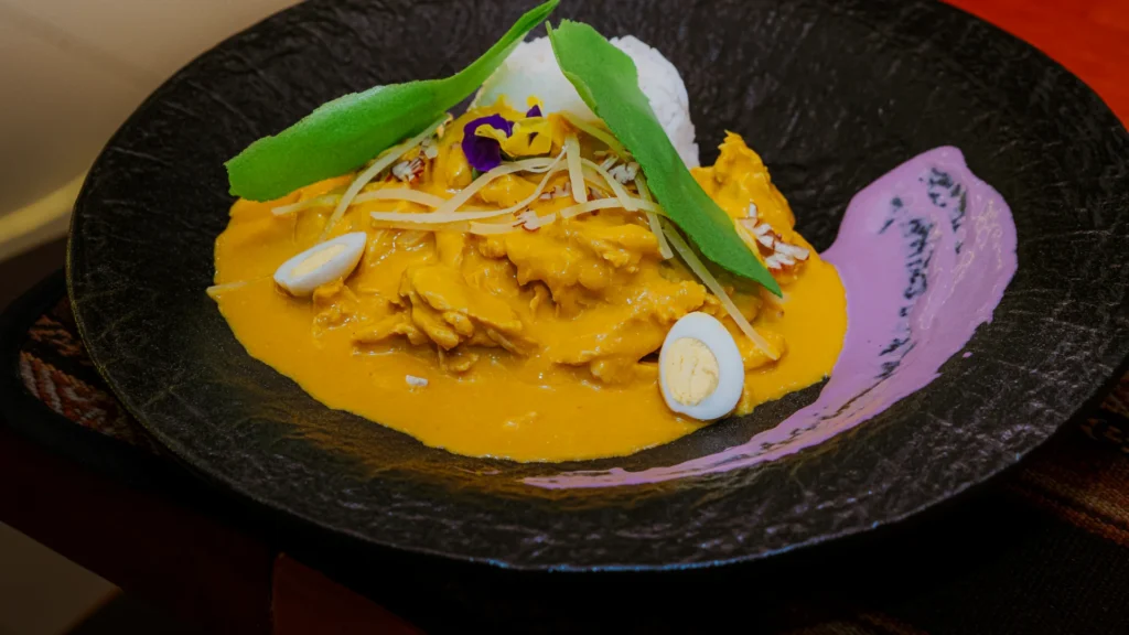 Gourmet ají de gallina with quail egg and potato paper at Moray, Cusco