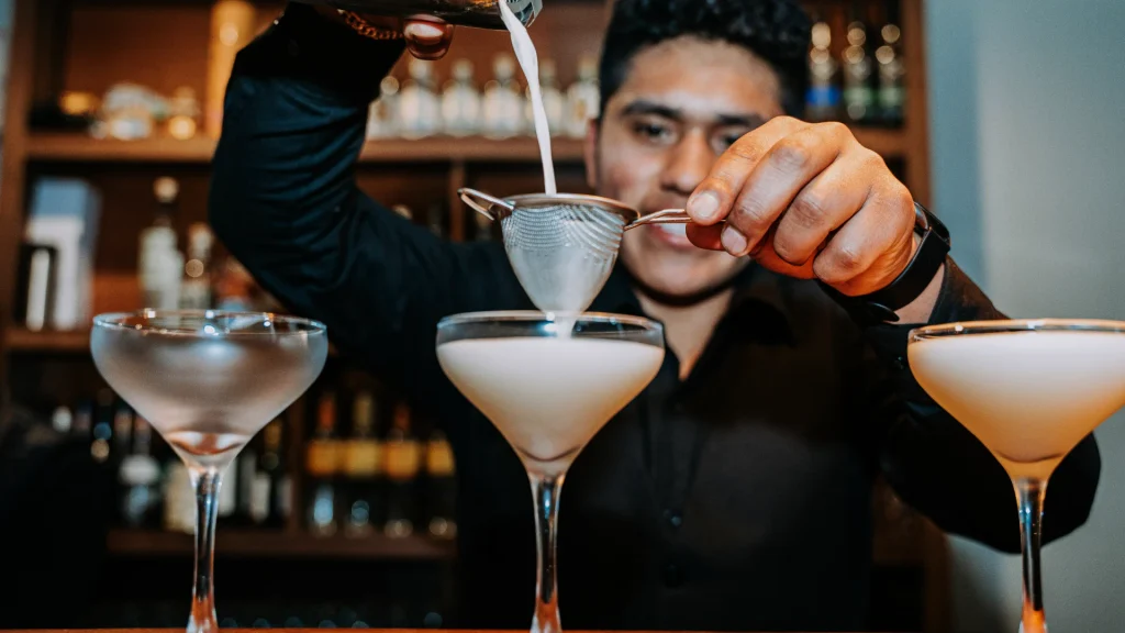 Bartender pouring pisco cocktails at Moray, Cusco