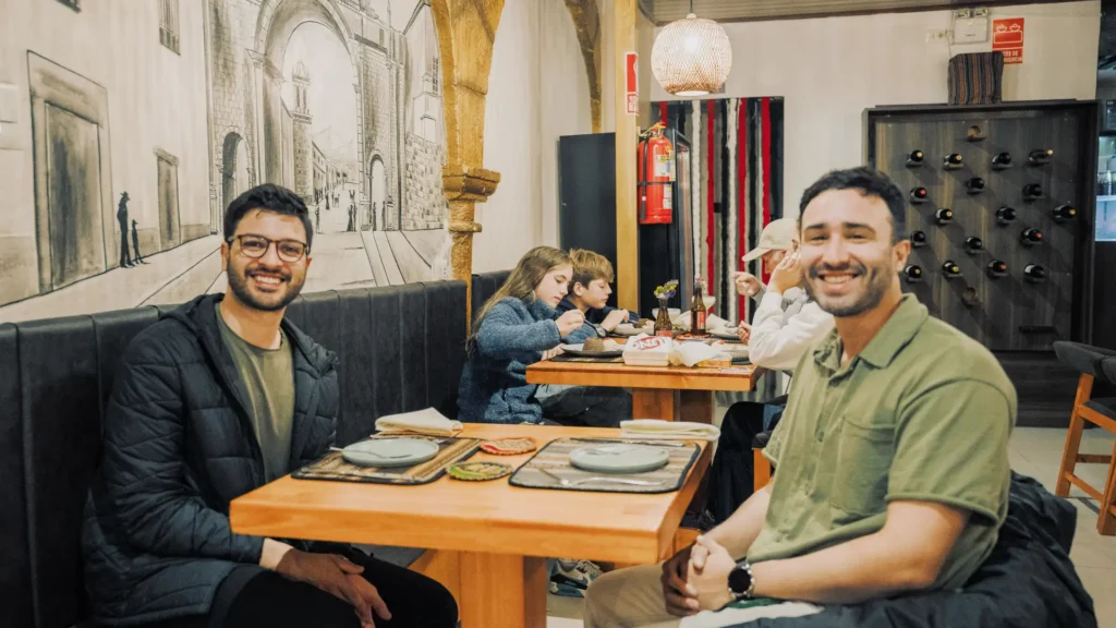 Guests at a table in front of a colonial Cusco mural at Moray